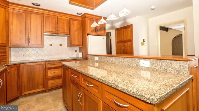 a bathroom with a granite countertop sink and a large mirror