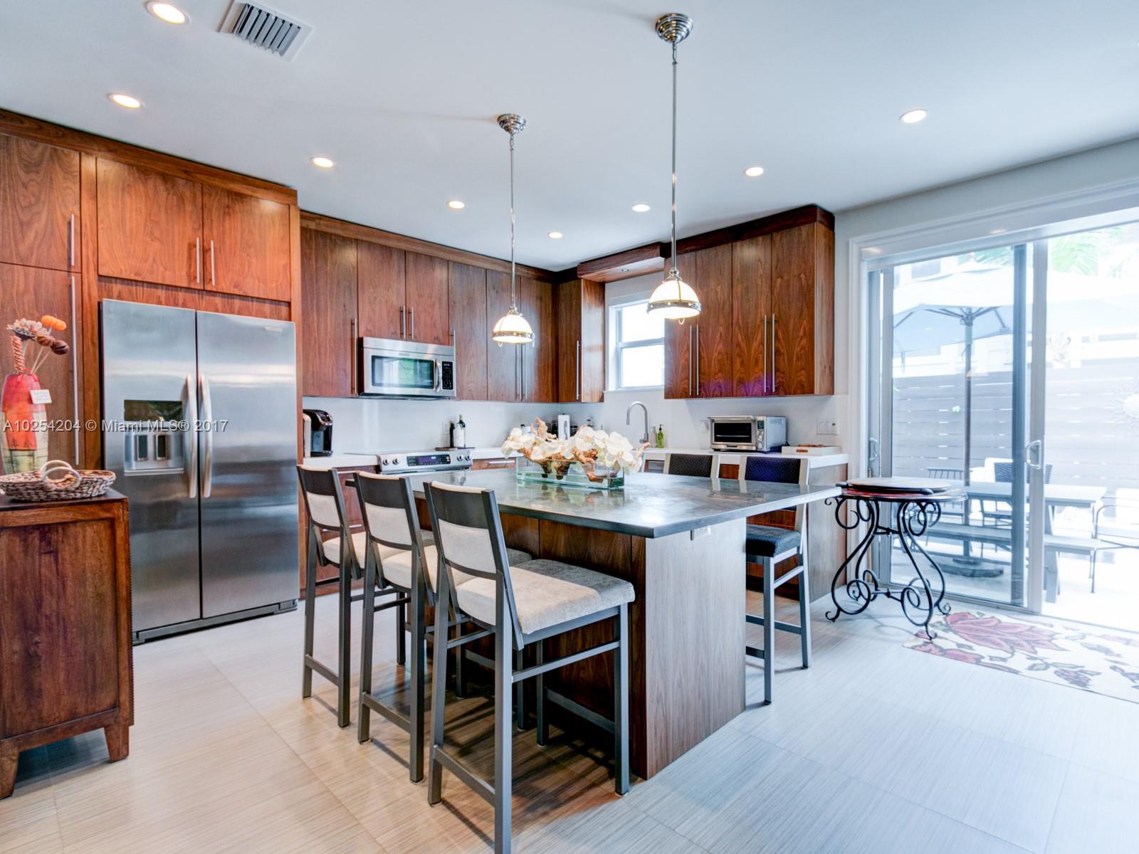 2993 Ruth Street, Unit 2993 Coconut Grove, FL 33133 - Photo 12 of 29 a kitchen with stainless steel appliances granite countertop a stove a refrigerator a kitchen island a table and chairs