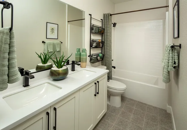 a bathroom with a granite countertop sink a toilet and shower