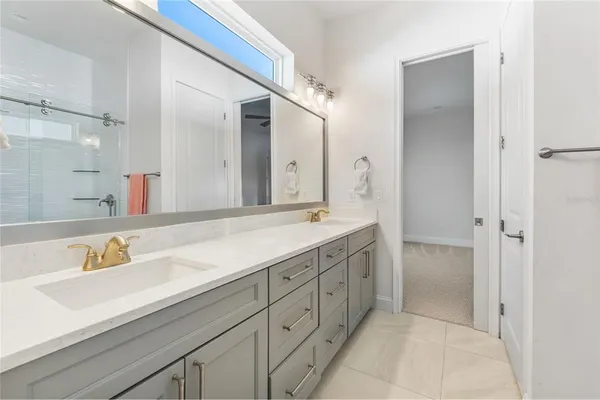a spacious bathroom with a shower sink and mirror