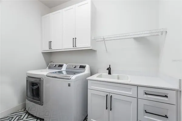 a utility room with sink dryer and washer