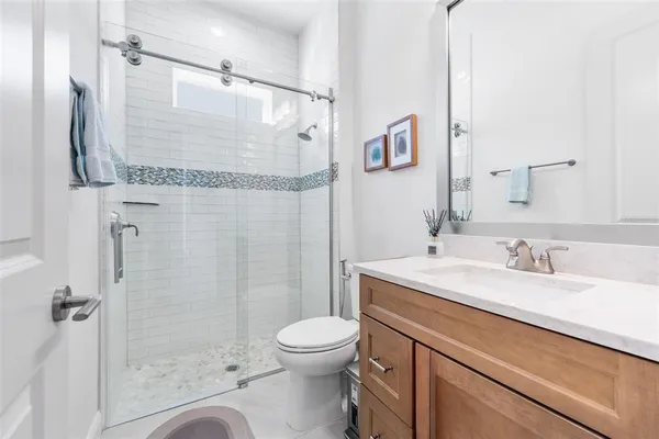 a bathroom with a granite countertop sink toilet and shower