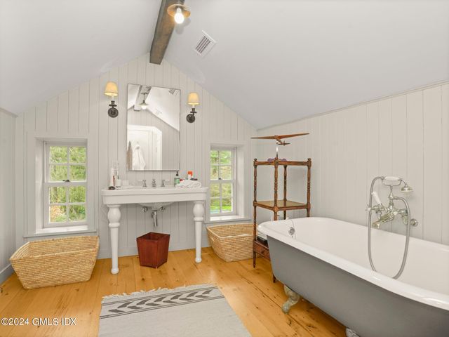 a bathroom with a tub sink and mirror