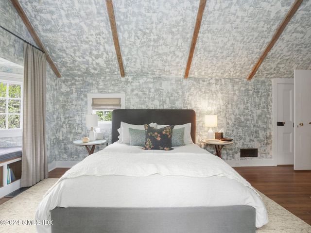 a large bed sitting in a bedroom next to a window