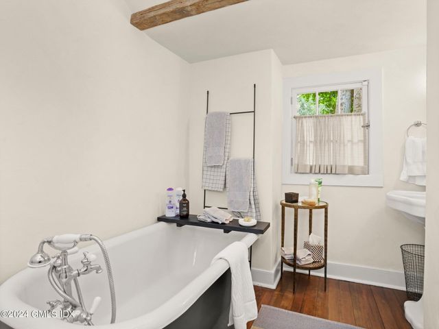 a room with a bed a window and wooden floor