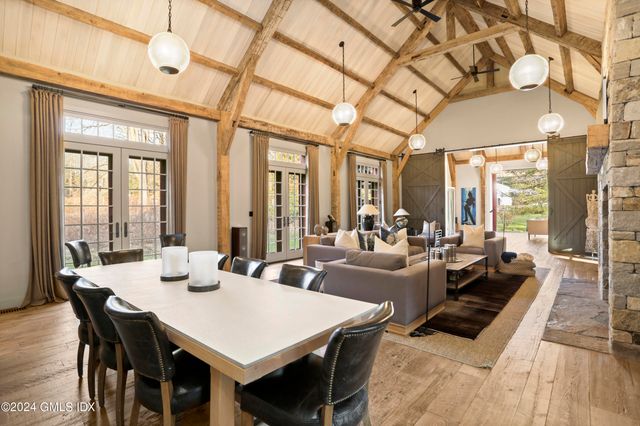 a view of a dining room with furniture large windows and wooden floor