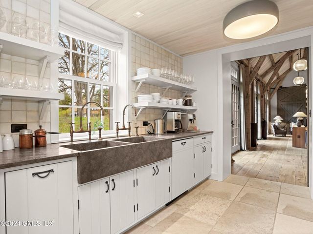 a kitchen with granite countertop a sink and white cabinets