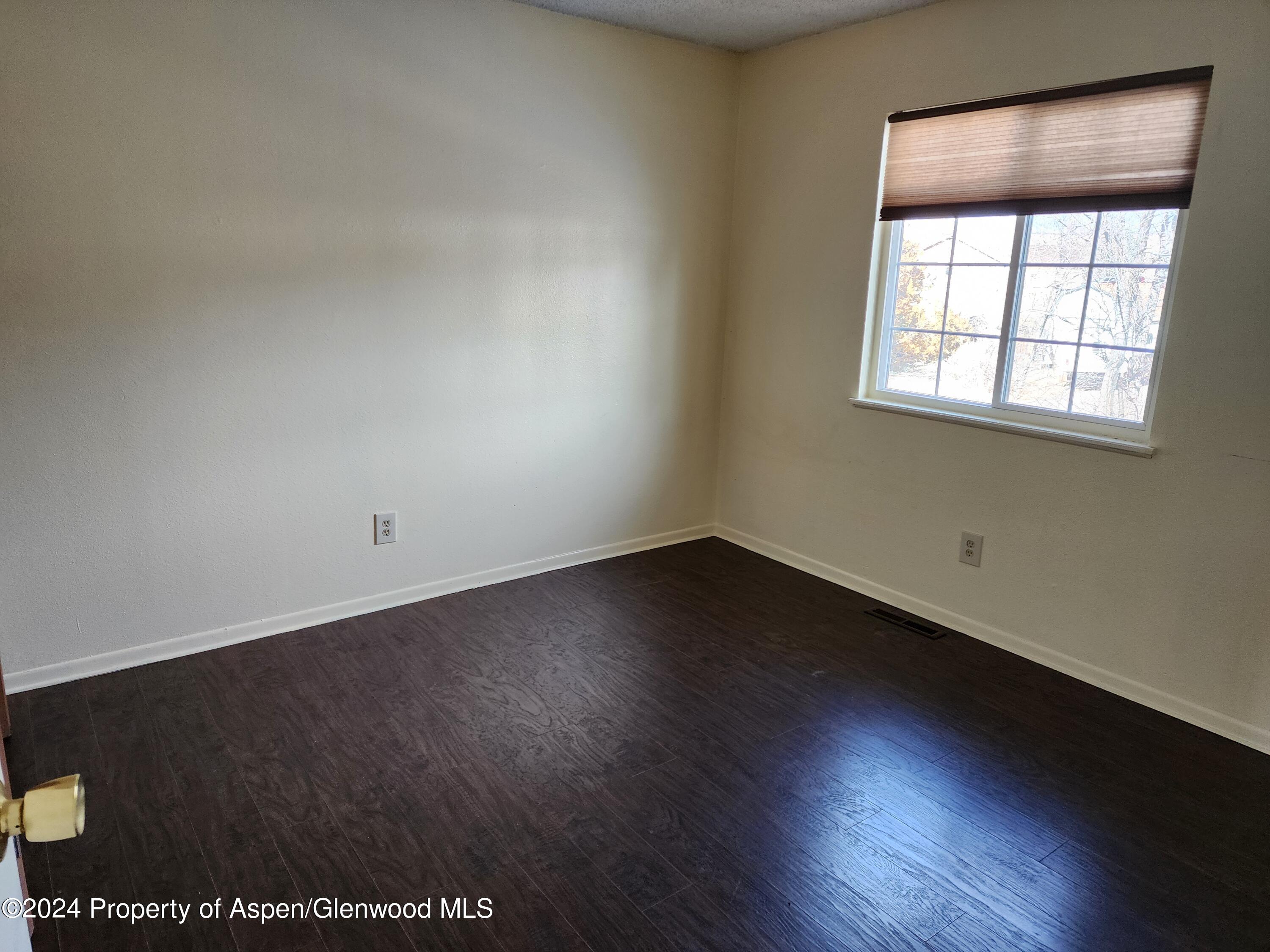 525 East 12th Street Rifle, CO 81650 - Photo 11 of 26 an empty room with wooden floor and windows