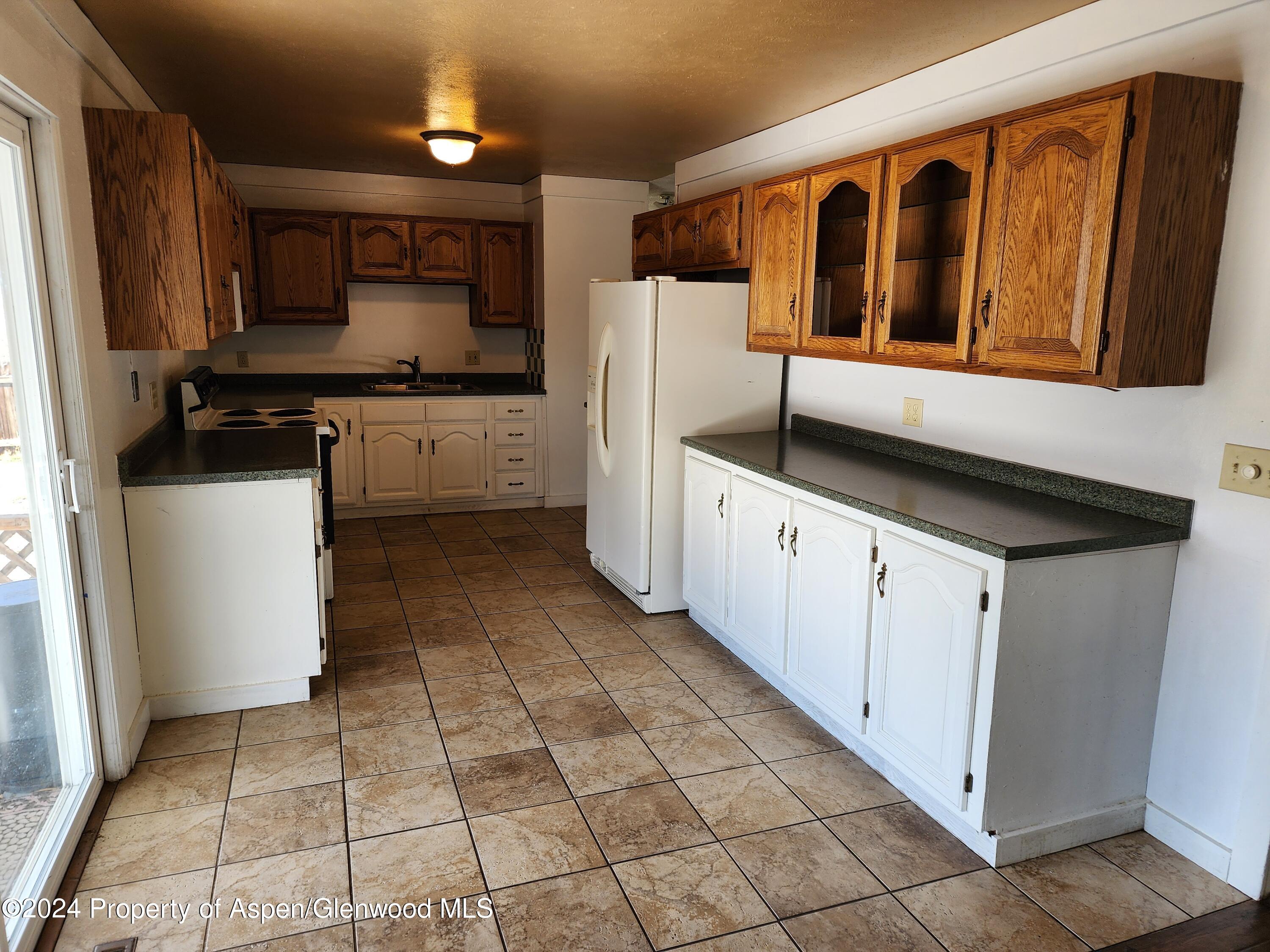 525 East 12th Street Rifle, CO 81650 - Photo 23 of 26 a kitchen with granite countertop a sink a counter top space and cabinets