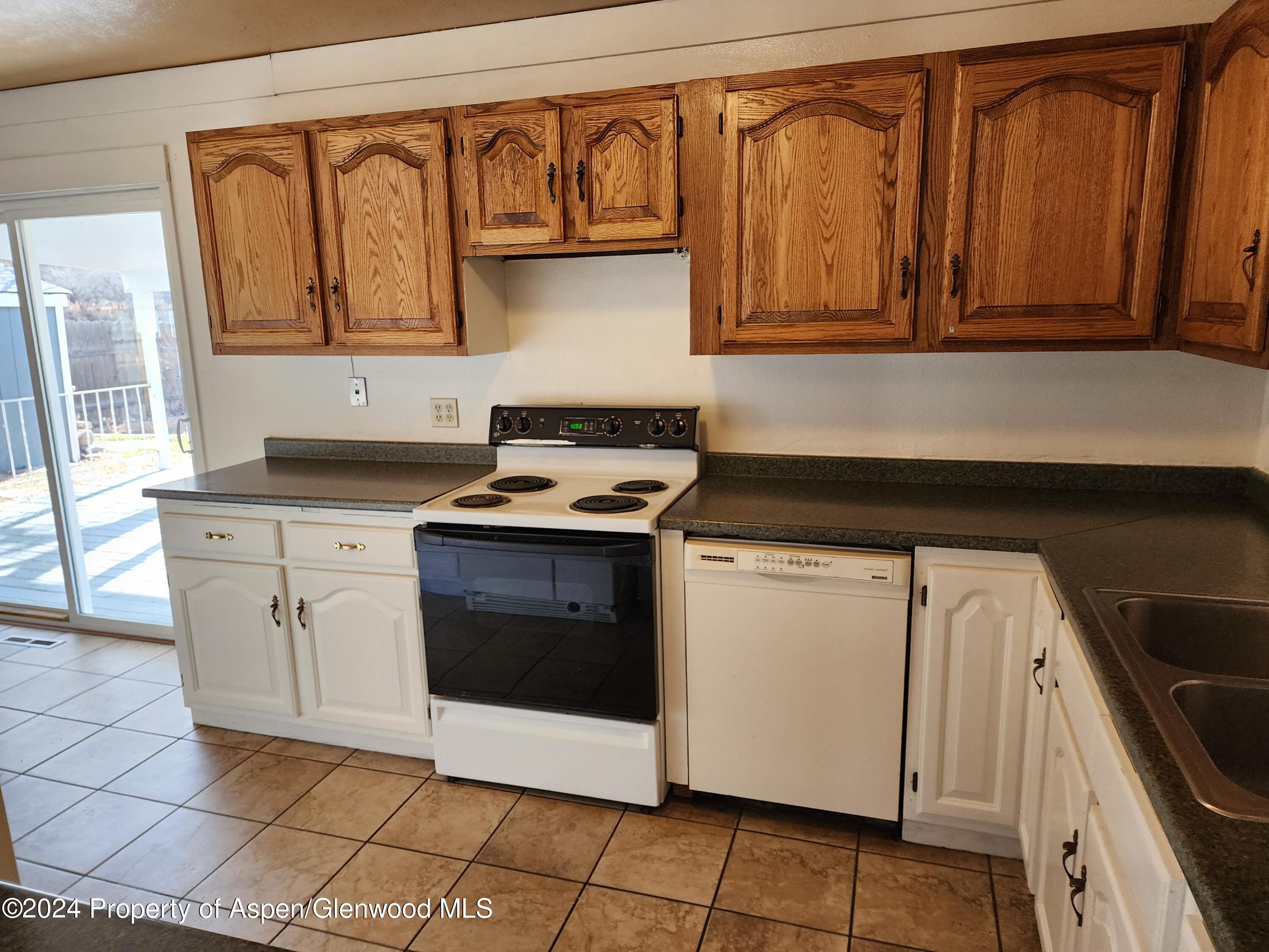 525 East 12th Street Rifle, CO 81650 - Photo 3 of 26 a kitchen with stainless steel appliances granite countertop a stove a sink and a microwave