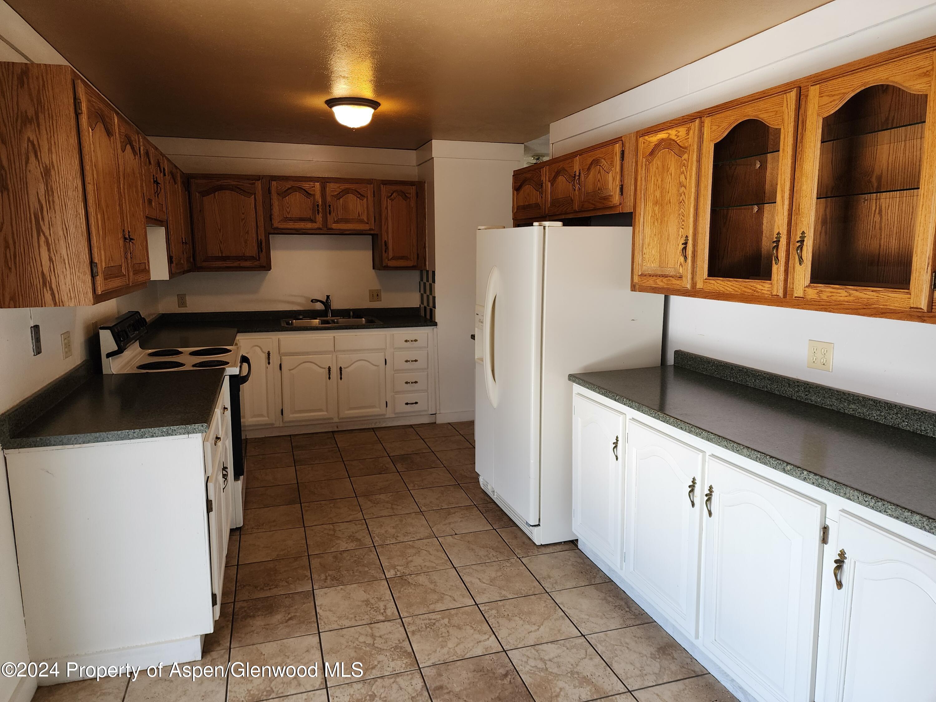 525 East 12th Street Rifle, CO 81650 - Photo 7 of 26 a kitchen with stainless steel appliances a refrigerator sink and cabinets