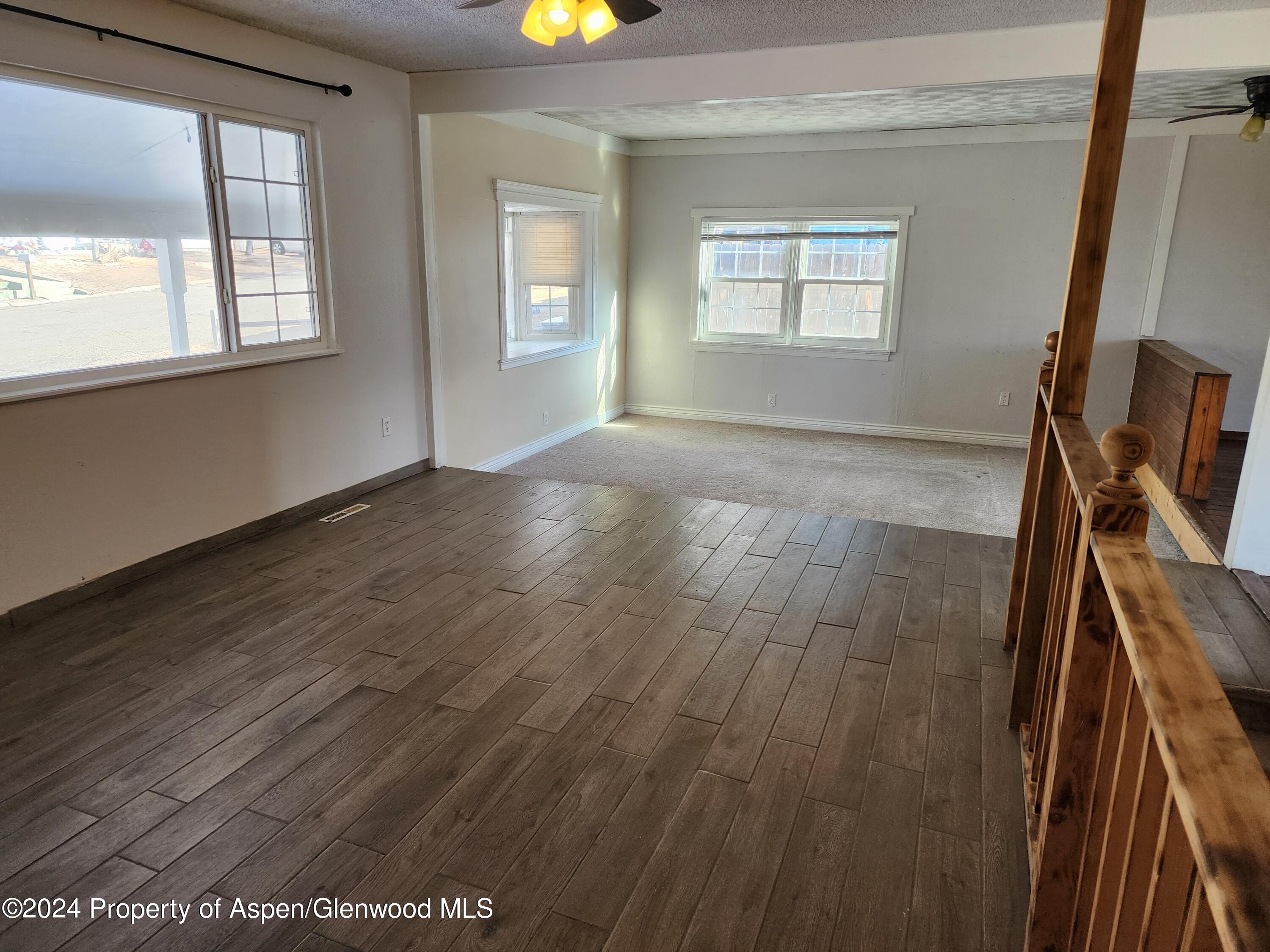 525 East 12th Street Rifle, CO 81650 - Photo 10 of 26 an empty room with wooden floor and windows