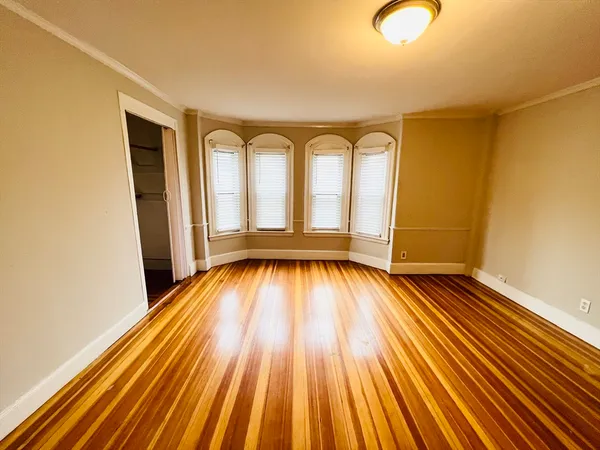 a view of empty room with wooden floor