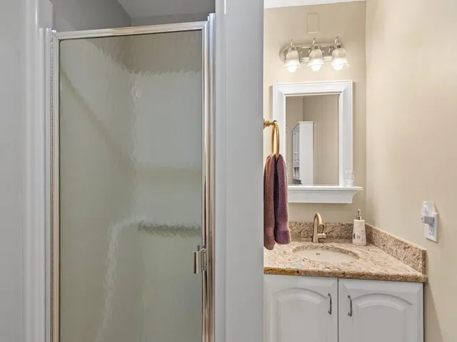 a bathroom with a granite countertop sink and a mirror