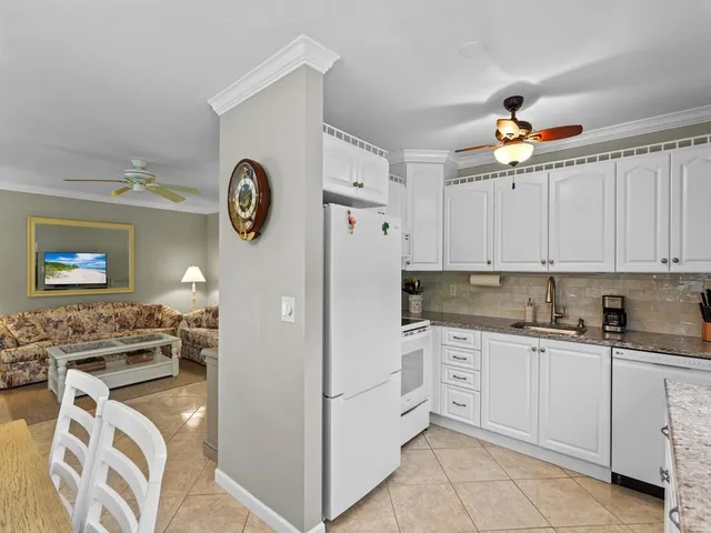 a kitchen with stainless steel appliances granite countertop a refrigerator sink and white cabinets