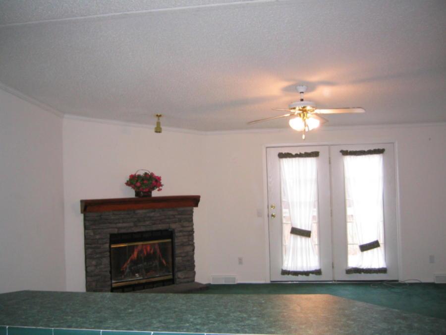 2560 Novelty Road Penhook, VA 24137 - Photo 2 of 5 a view of an empty room with chandelier fan and fire place