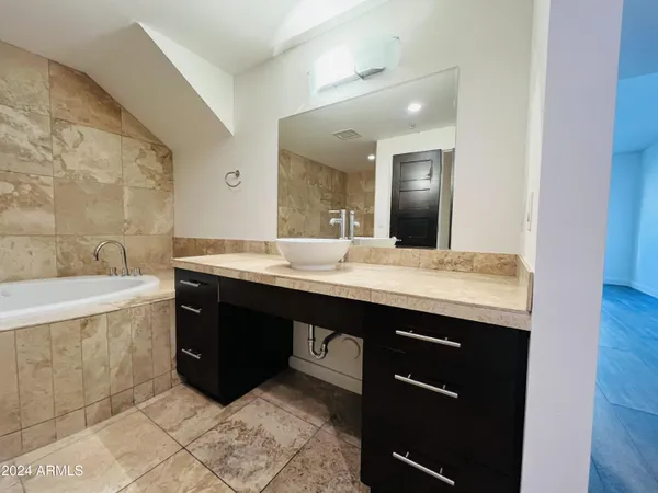 a bathroom with a granite countertop bathtub and toilet
