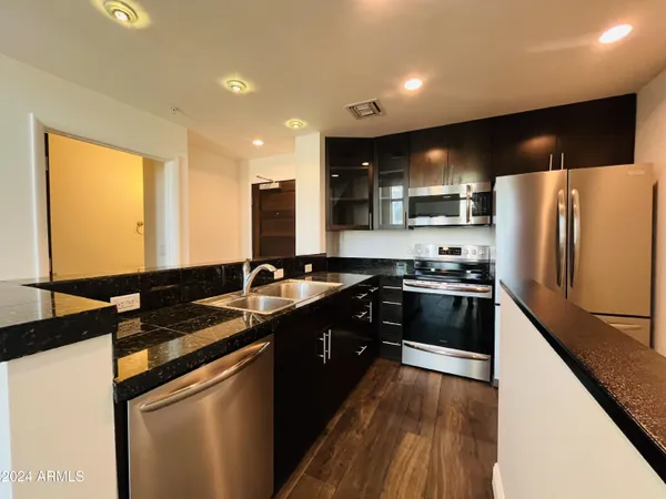 a view of a kitchen with wooden floor and a sink