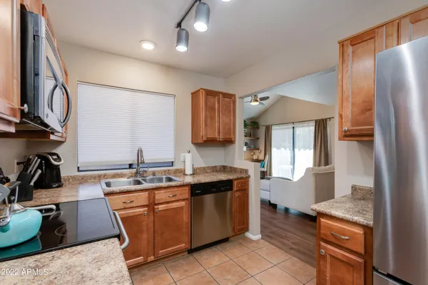 a kitchen with stainless steel appliances granite countertop a stove top oven a sink dishwasher and a microwave oven on the blue kitchen countertops