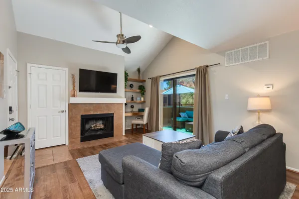 a living room with furniture a fireplace and a flat screen tv