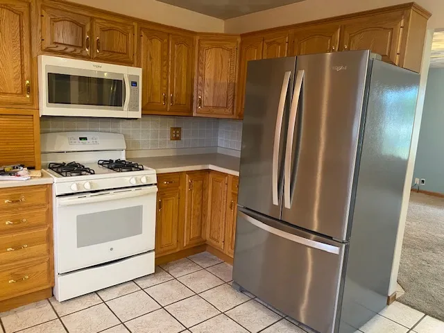 a kitchen with stainless steel appliances granite countertop a refrigerator stove and microwave
