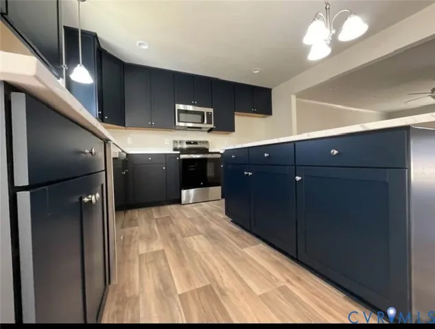 a kitchen with stainless steel appliances granite countertop a refrigerator and a sink