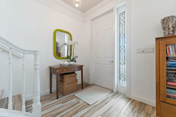 a living room with a mirror and a wooden floor
