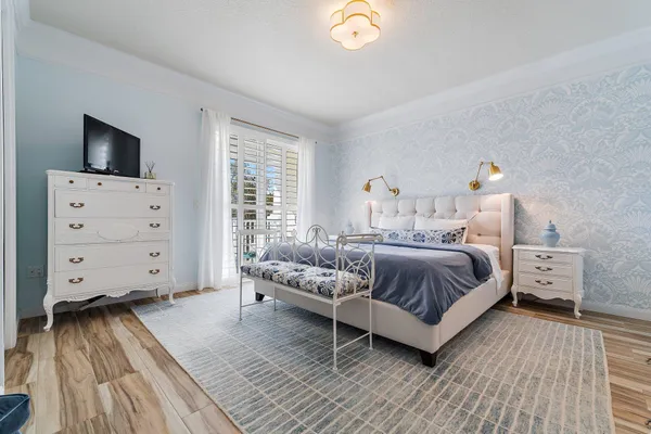 a bedroom with a bed and a flat tv screen on dresser