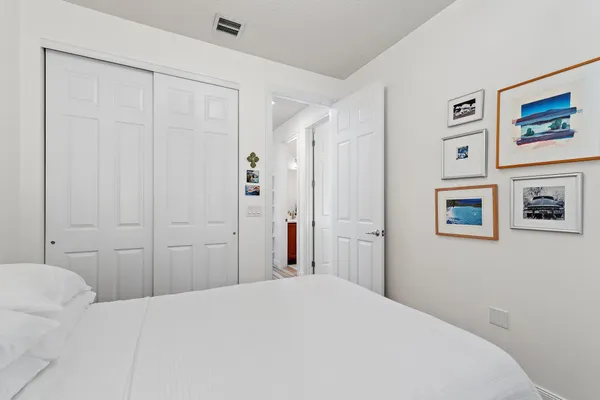 a bedroom with a bed and painting on the wall