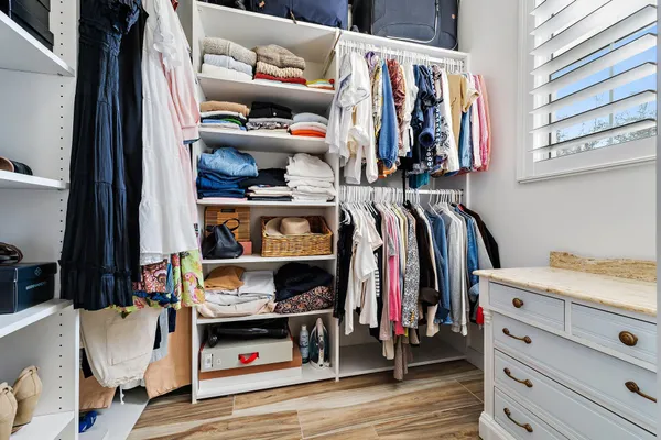 a view of walk in closet with clothes and shoes