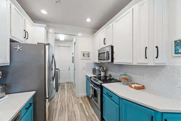 a kitchen with stainless steel appliances granite countertop a refrigerator sink and white cabinets