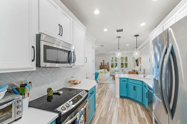 a kitchen that has a lot of cabinets a sink and appliances