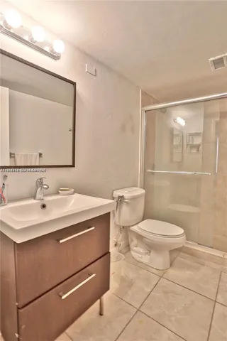 a bathroom with a sink a toilet a mirror and shower