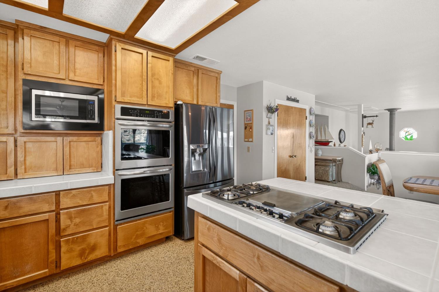 28037 Sky Harbour Road Friant, CA 93626 - Photo 12 of 40 a kitchen with stainless steel appliances granite countertop a stove and a refrigerator