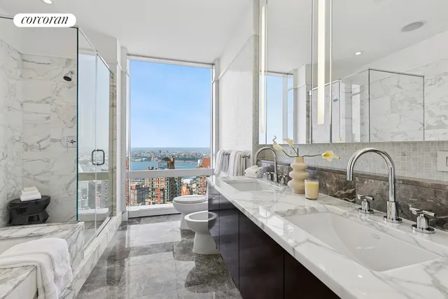 a bedroom with a bed a chandelier and a large window