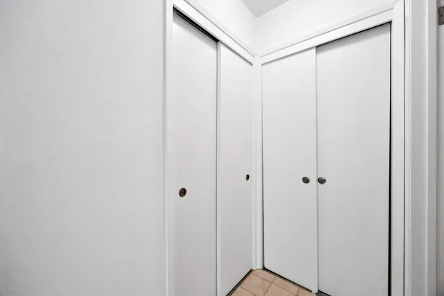a view of a hallway with wooden floor and closet