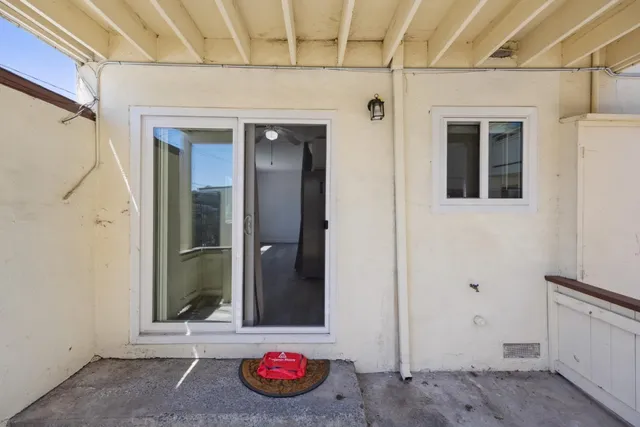 a living room with furniture a flat screen tv and a floor to ceiling window