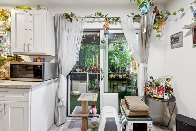 a kitchen with stainless steel appliances a stove top oven a refrigerator and a view of living room