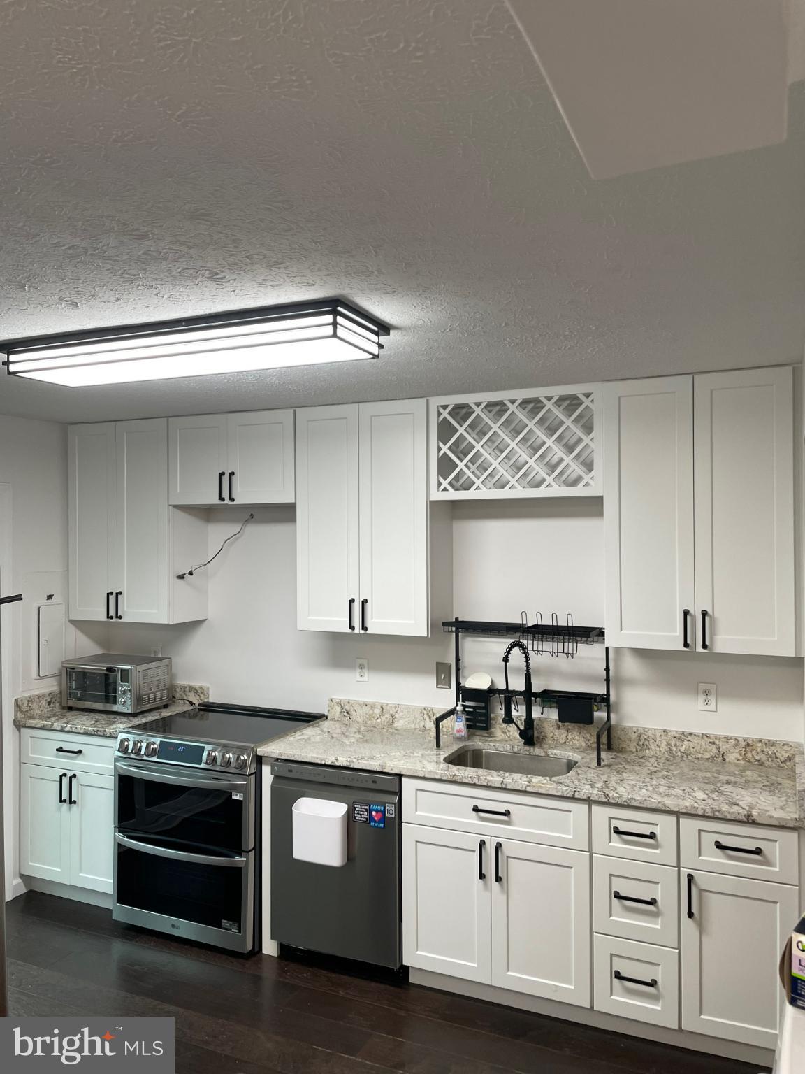 7105 Split Rail Lane Laurel, MD 20707 - Photo 9 of 12 a kitchen with granite countertop white cabinets and stainless steel appliances