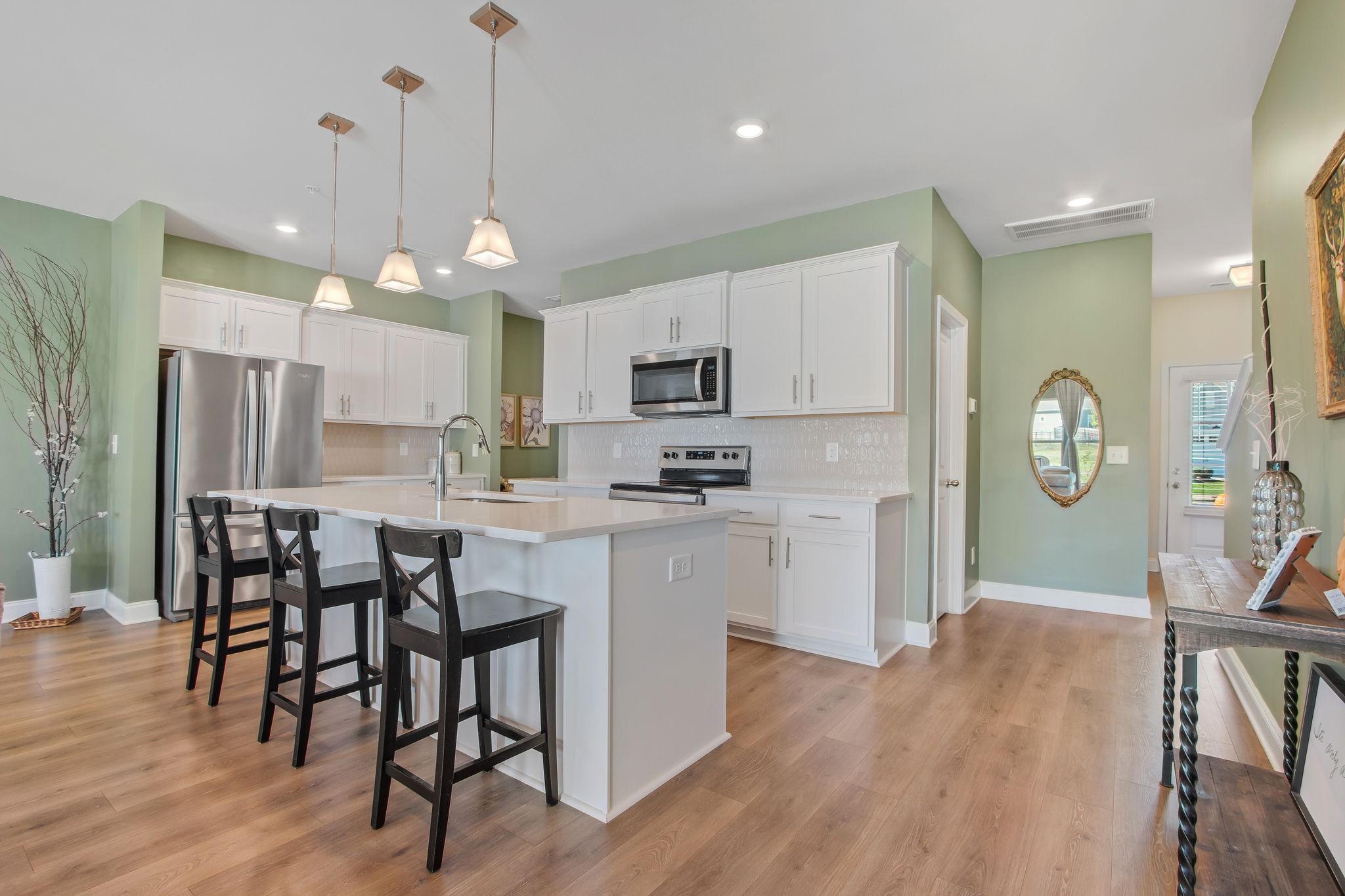 1012 June Wilde Ridge Spring Hill, TN 37174 - Photo 11 of 49 a kitchen with stainless steel appliances a dining table chairs stove refrigerator and cabinets