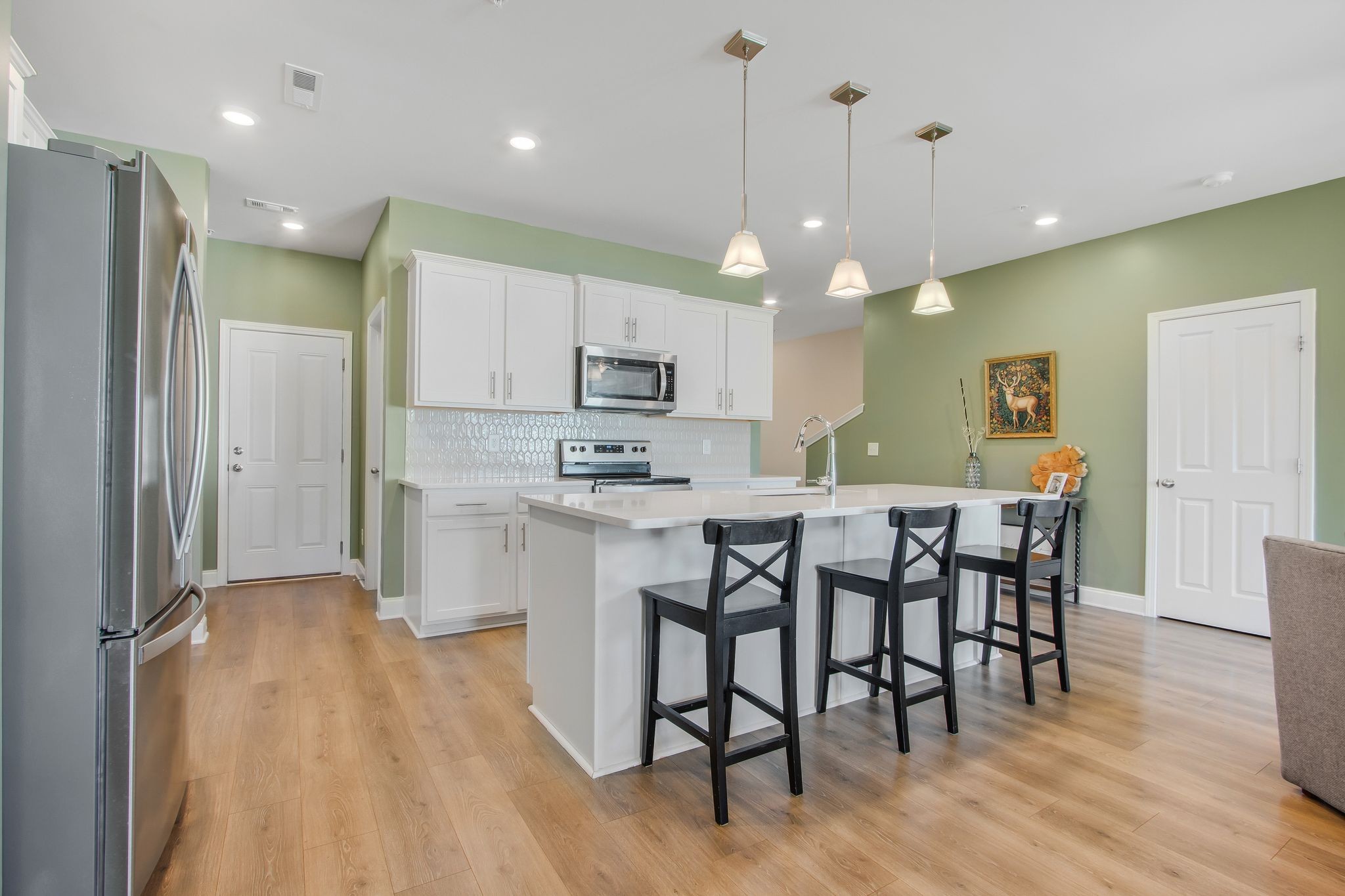 1012 June Wilde Ridge Spring Hill, TN 37174 - Photo 12 of 49 a kitchen with kitchen island granite countertop a sink a center island stainless steel appliances and cabinets