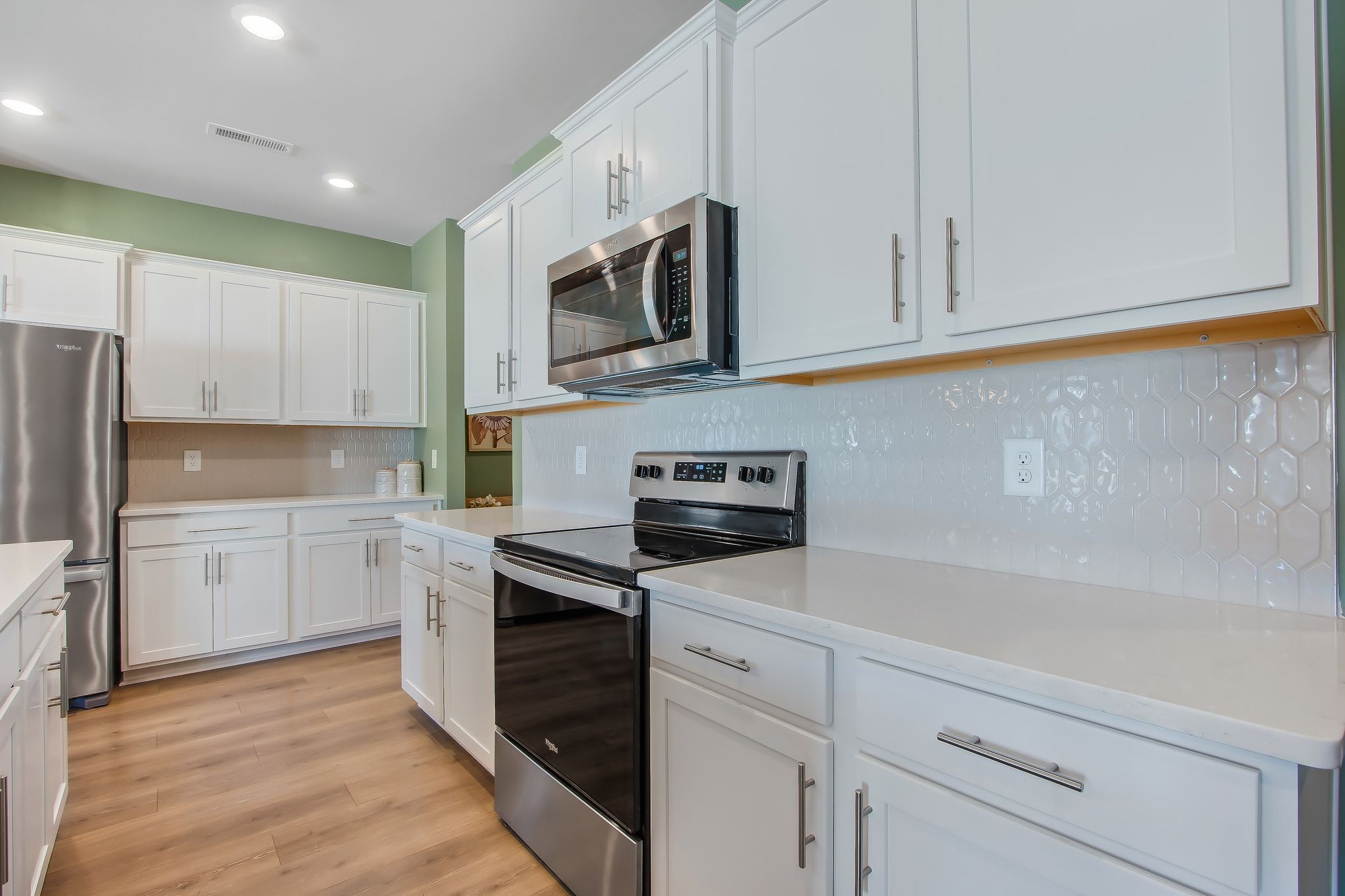 1012 June Wilde Ridge Spring Hill, TN 37174 - Photo 14 of 49 a kitchen with white cabinets stainless steel appliances and a sink