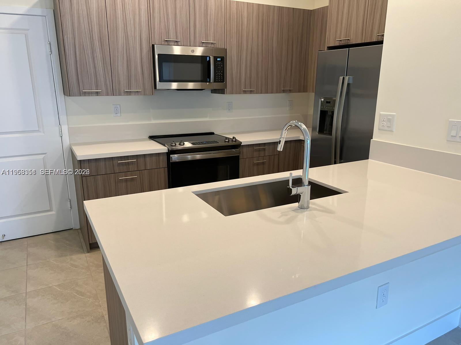 4622 Northwest 83rd Path Doral, FL 33166 - Photo 10 of 13 a kitchen with stainless steel appliances a sink a stove a microwave a refrigerator a sink and a stove