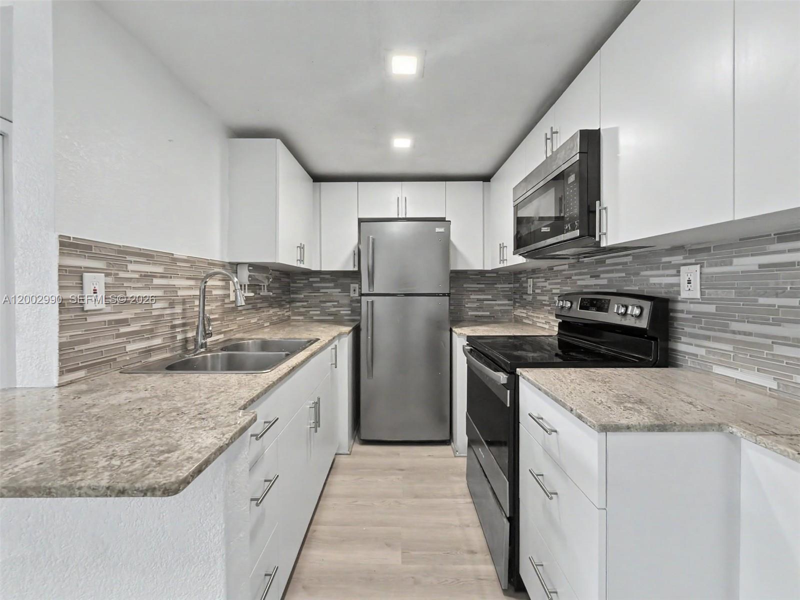 606 West 81st Street, Unit 120 Hialeah, FL 33014 - Photo 1 of 14 a kitchen with stainless steel appliances granite countertop a sink stove and refrigerator