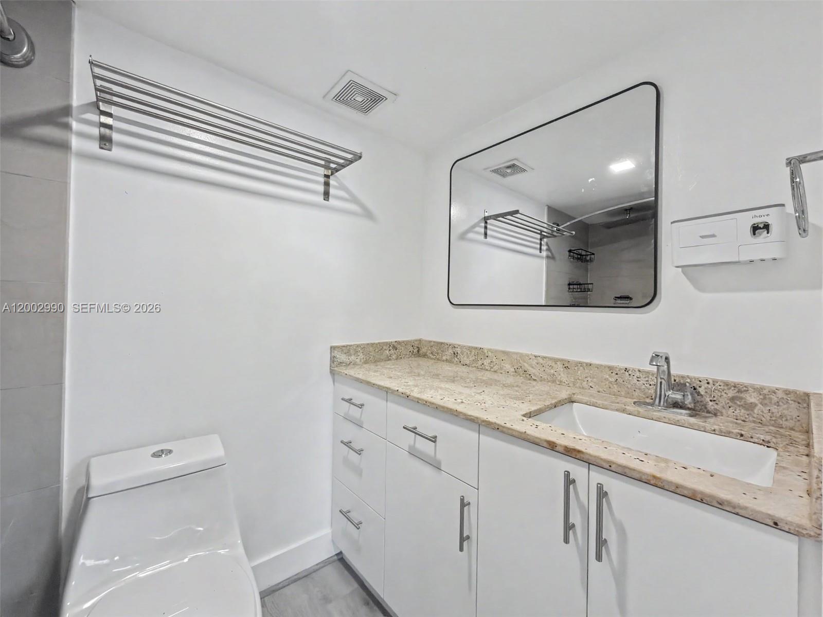 606 West 81st Street, Unit 120 Hialeah, FL 33014 - Photo 4 of 14 a bathroom with a sink a toilet and mirror