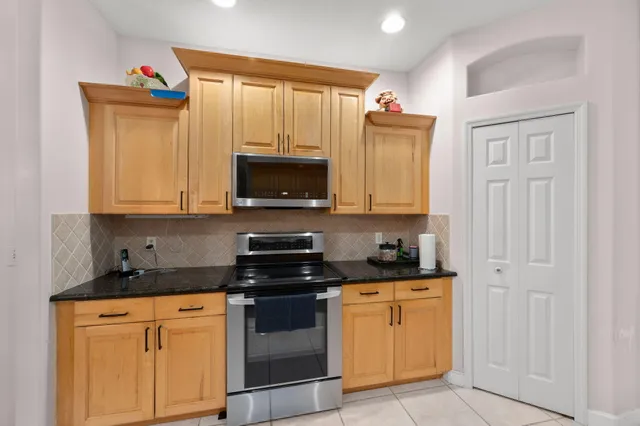 a kitchen with granite countertop white cabinets stainless steel appliances and a sink