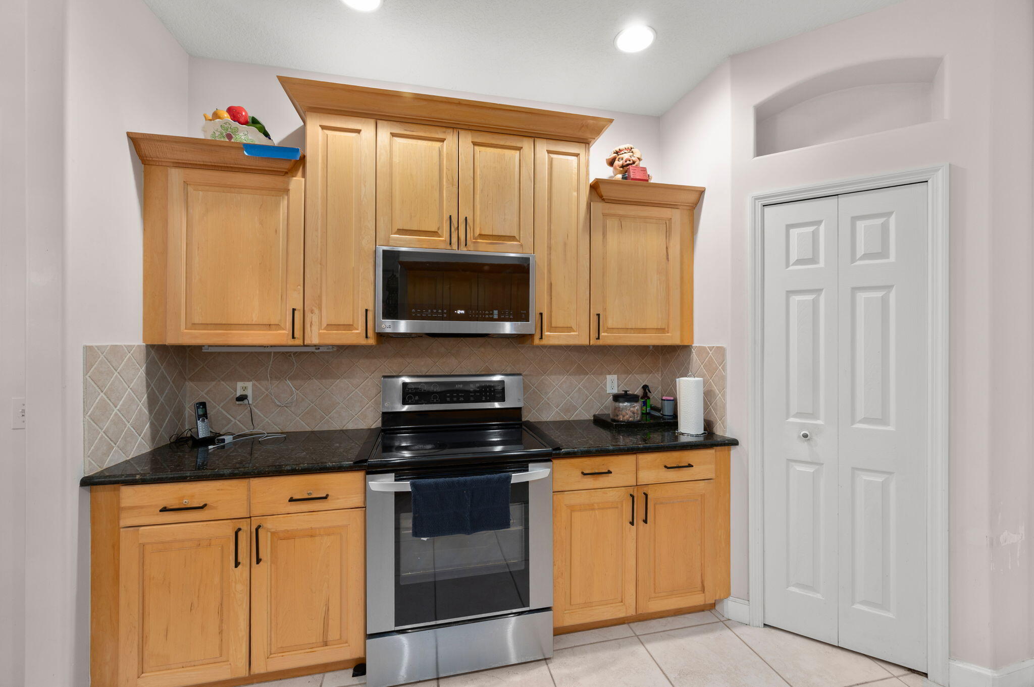 1545 Southwest Mockingbird Circle Port St. Lucie, FL 34986 - Photo 11 of 24 a kitchen with granite countertop white cabinets stainless steel appliances and a sink