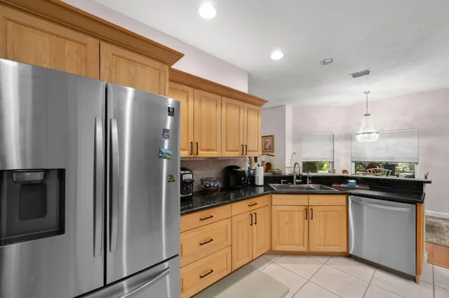 a kitchen with a sink a refrigerator and cabinets