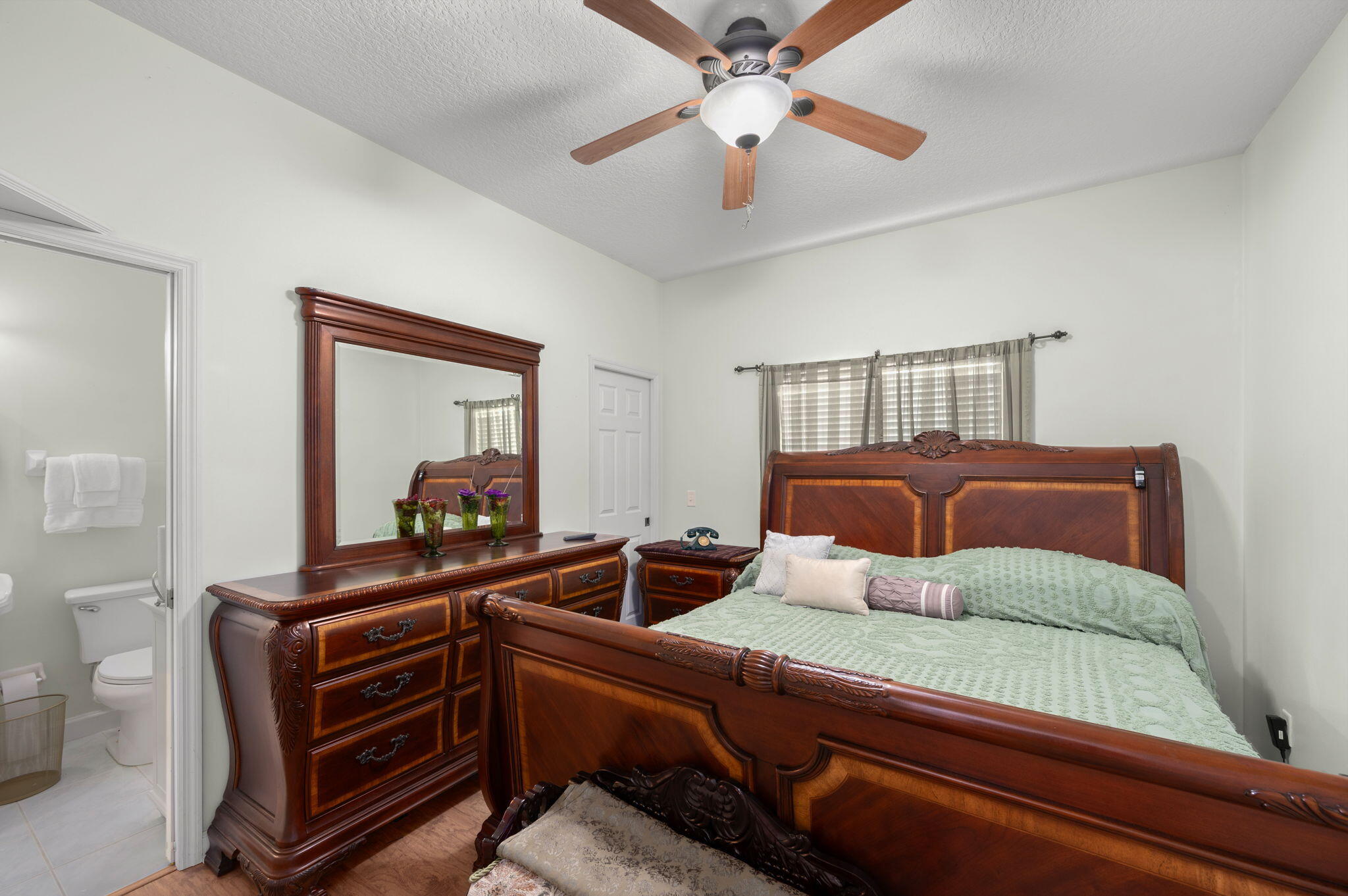 1545 Southwest Mockingbird Circle Port St. Lucie, FL 34986 - Photo 16 of 24 a bedroom with furniture and a mirror