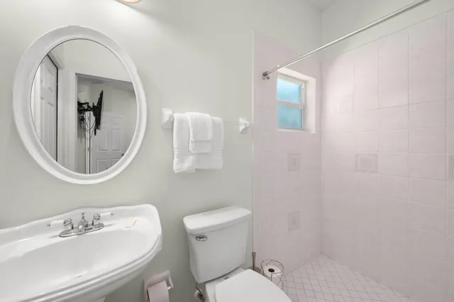 a bathroom with a toilet a sink and mirror